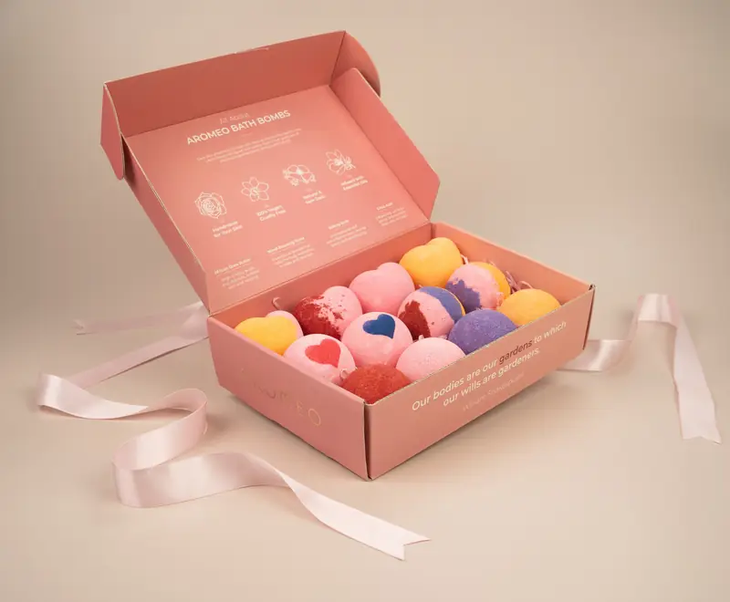 Pink gift box filled with colourful bath products and a ribbon