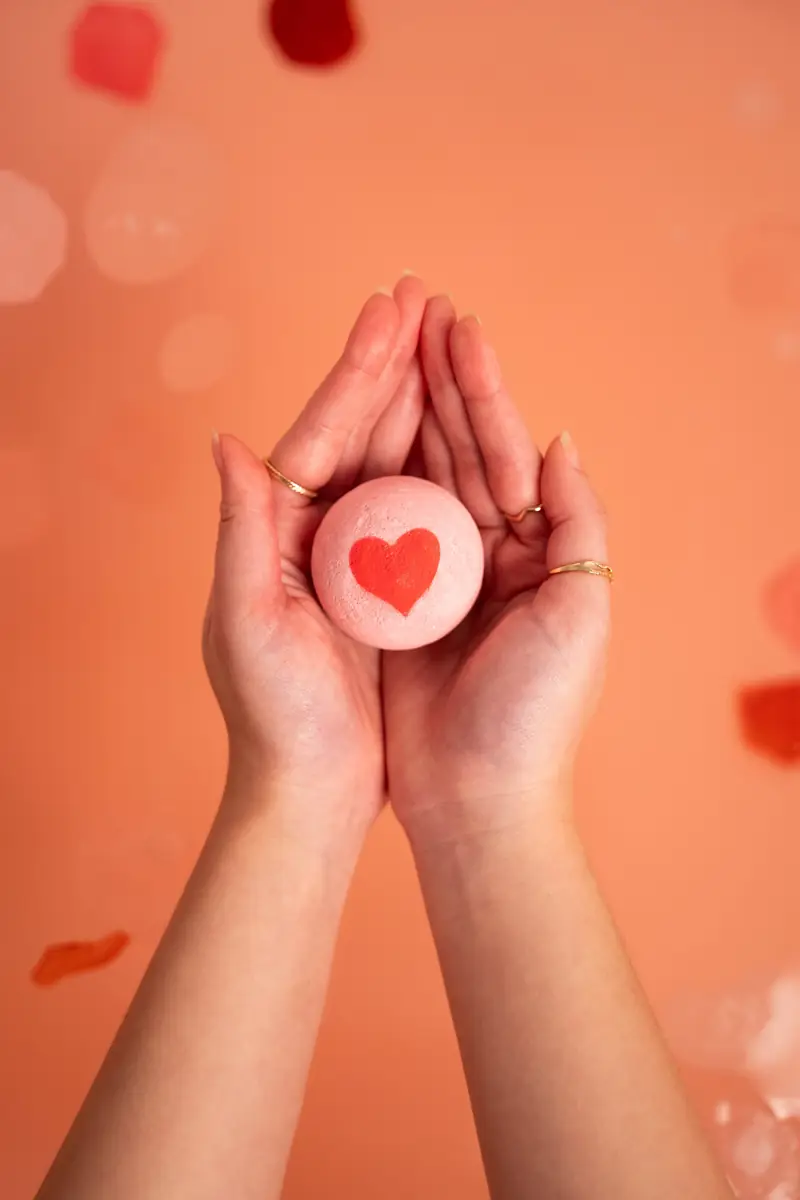 Hands holding a heart-shaped bath bomb