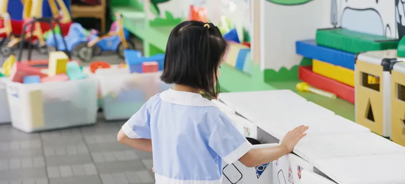 A child opening one of the upcycled cabinets in a classroom