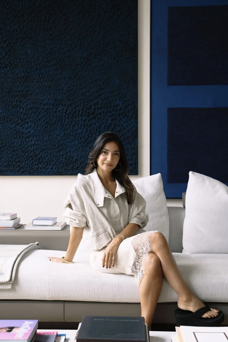 Deborah Guttieres seated on a white sofa in a styled living room