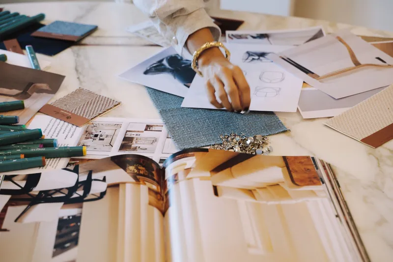 Hands sorting fabric and material samples on a table