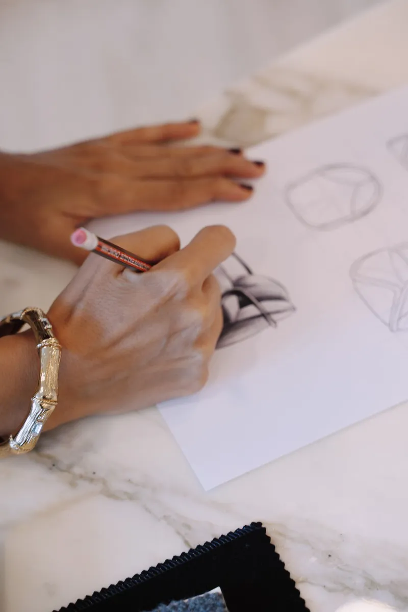 Close-up of a hand sketching a design on paper