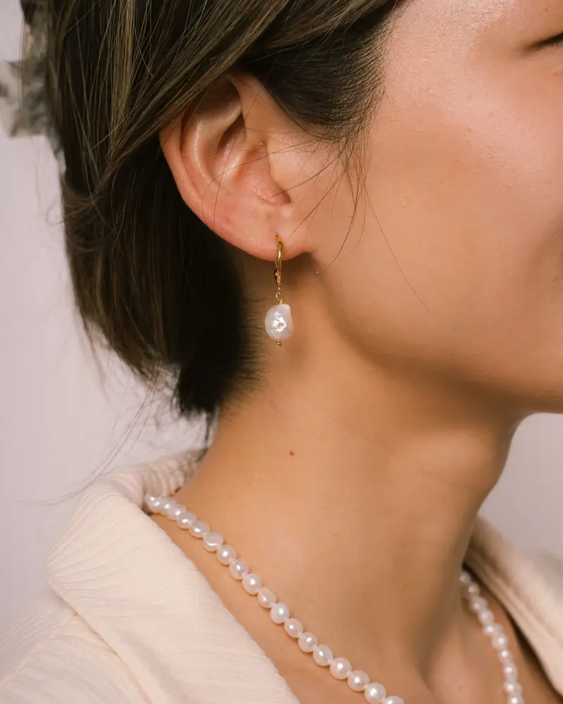 Close-up of a woman wearing a pearl necklace