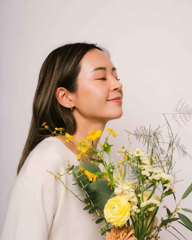 Model holding a bunch of yellow flowers
