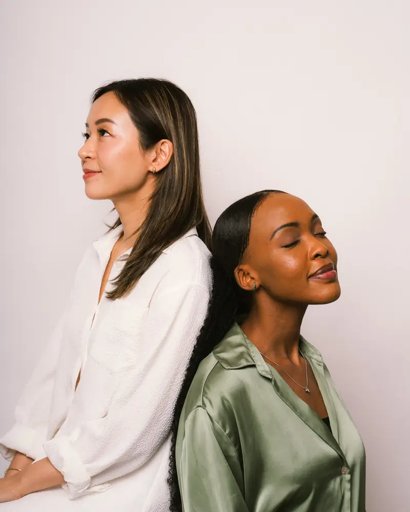 Two models sitting together in soft daylight