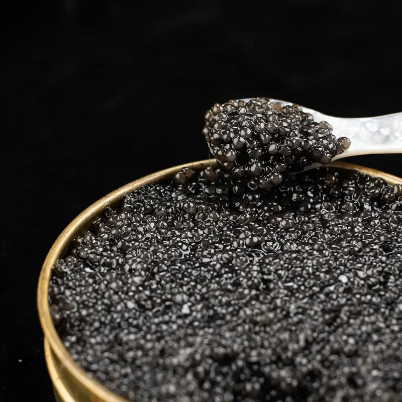 Spoon lifting caviar from a tin