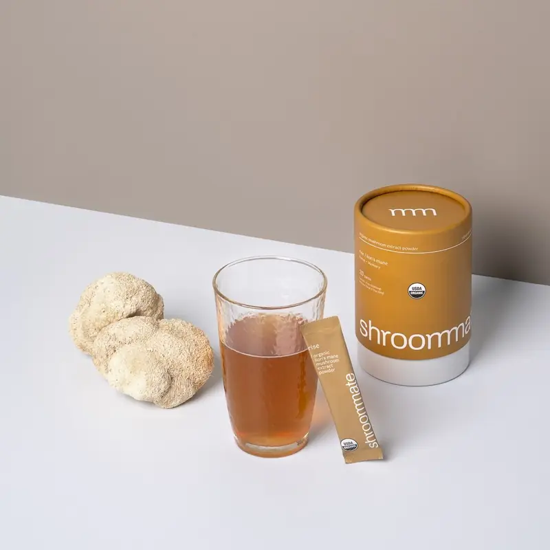Shroommate canister with a cup of tea and mushrooms