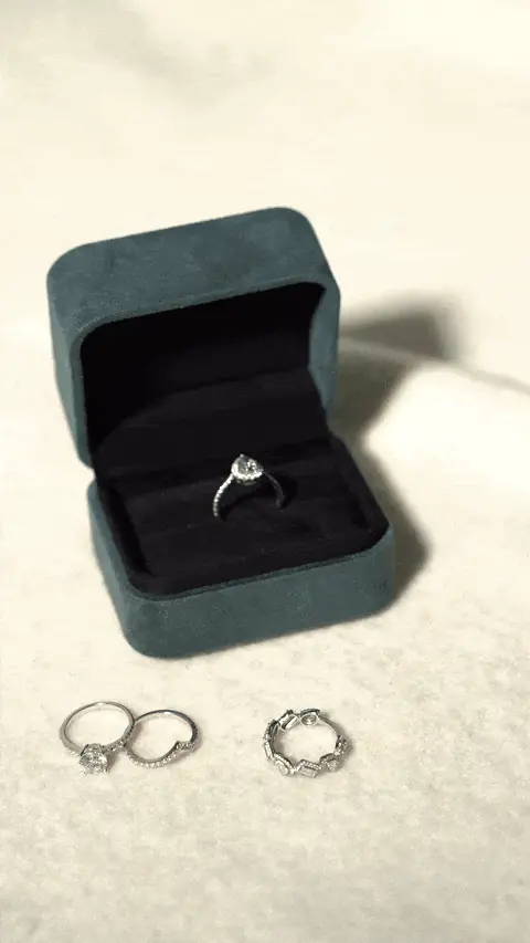 Ring box and two rings on a pale surface