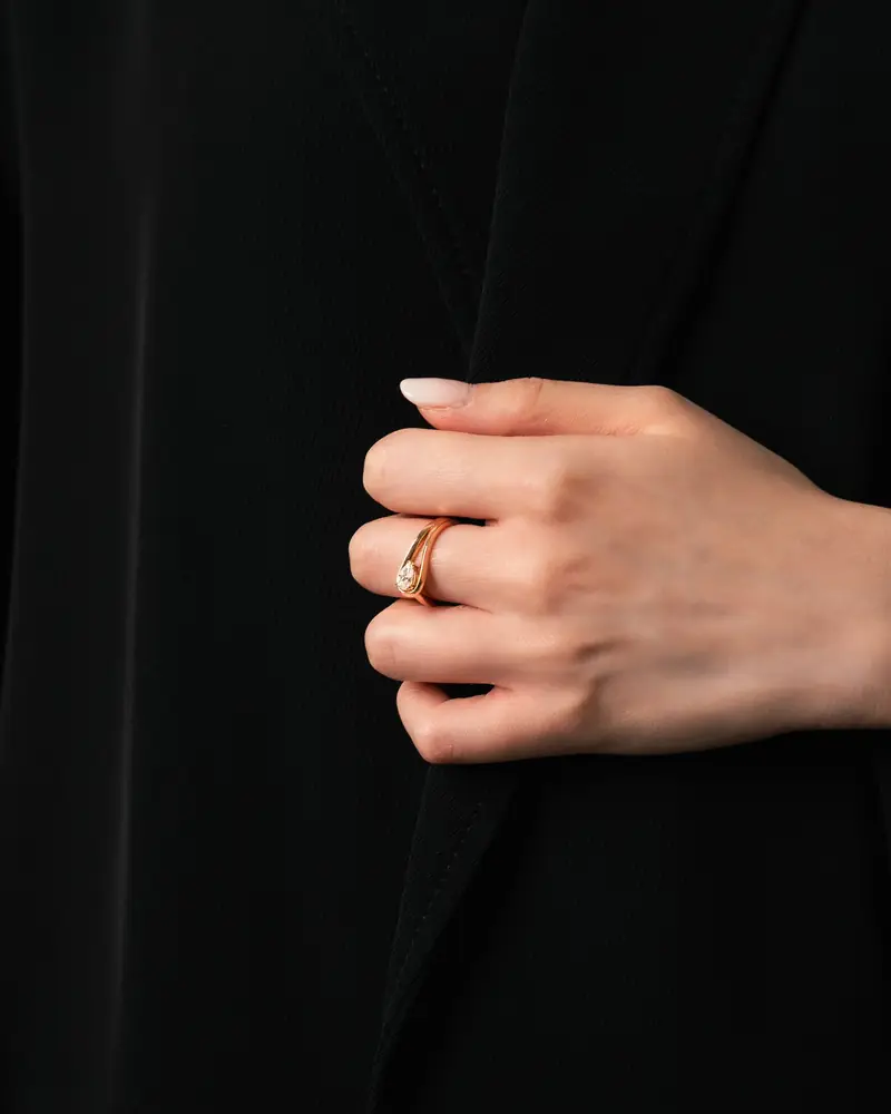 Hand with rings against a black background