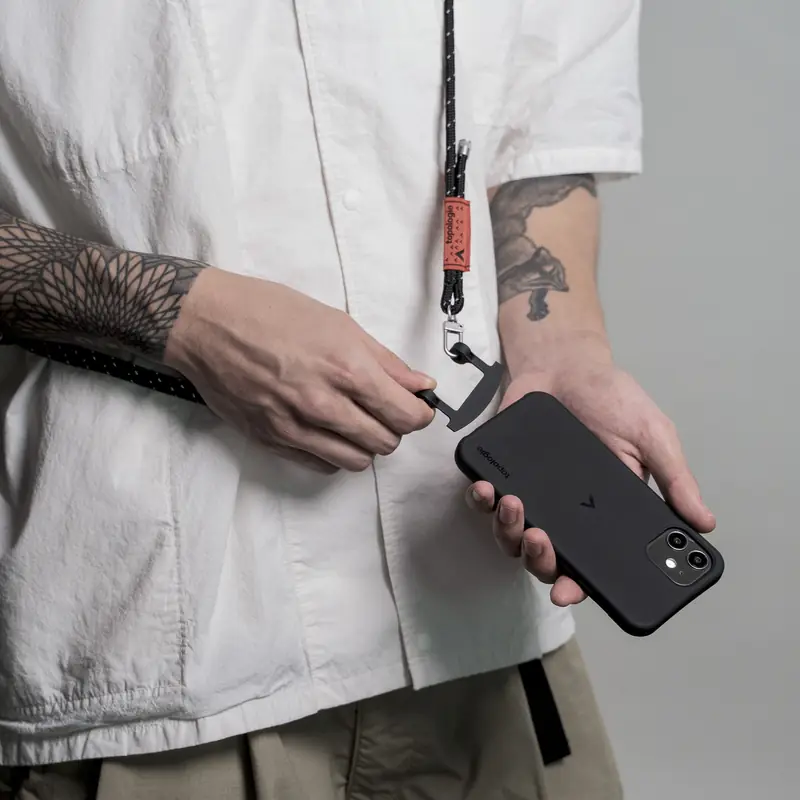 Model holding a phone on a crossbody strap