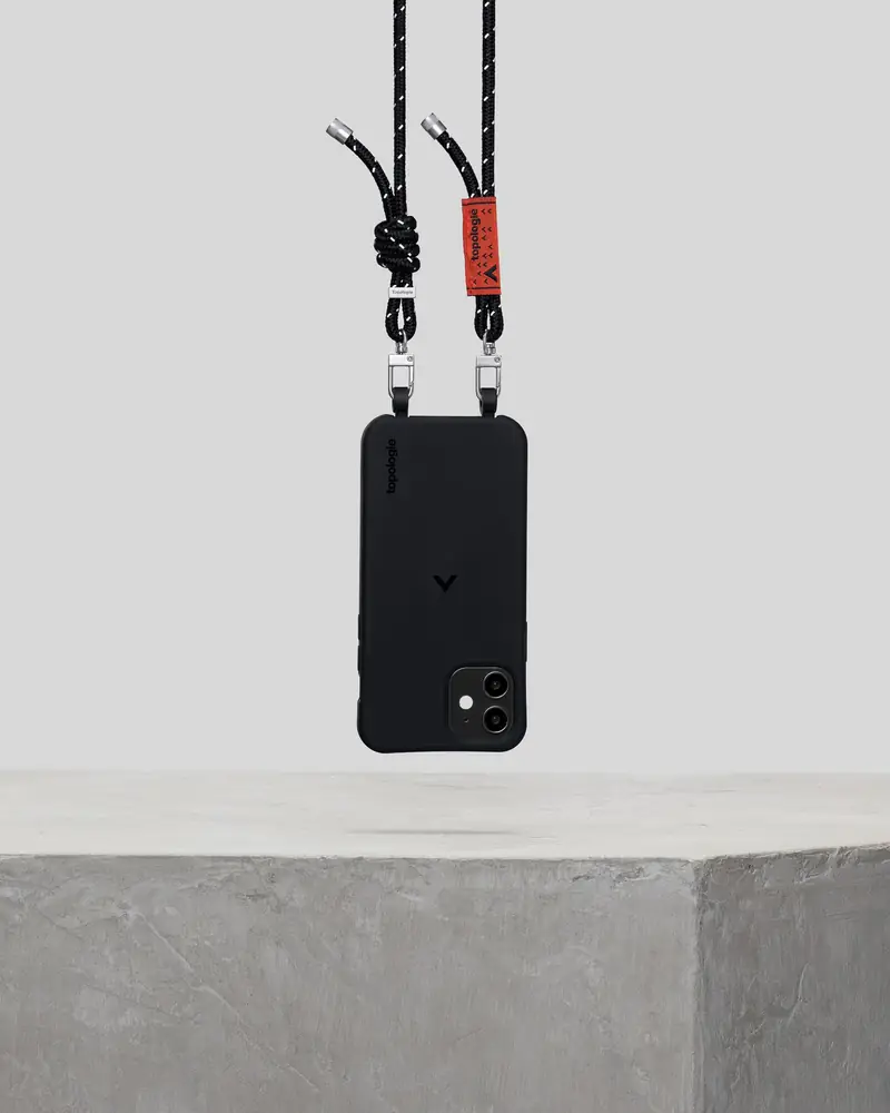 Phone case on a strap displayed on a concrete plinth