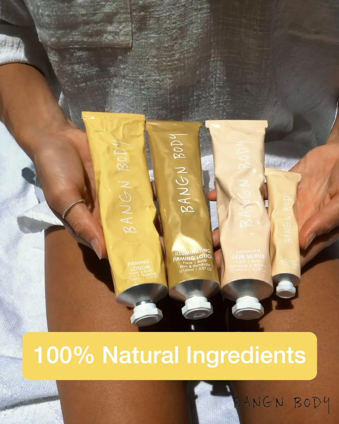 Hands holding a row of Bangn Body skincare tubes