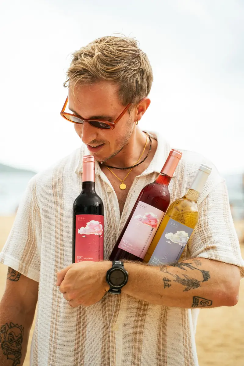 Man in sunglasses holding two bottles of wine